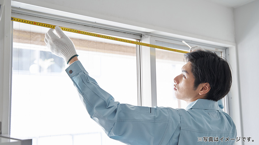 窓を採寸する作業員